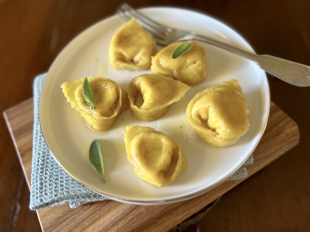 Stuffed tortelli with salame rosa, cheese, and sage pears
